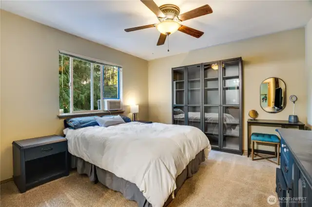 Primary bedroom with backyard tree-lined views, fresh paint, walk-in closet and an ensuite three-quarter bath.
