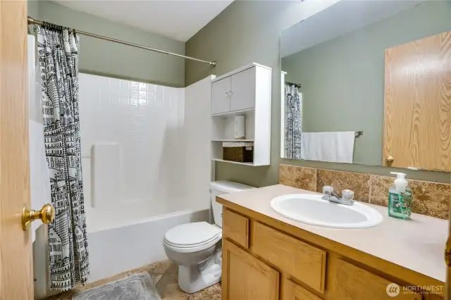 The second bathroom upstairs is a full bath with tub, tile floors, an oversized vanity, and is conveniently located between all bedrooms.