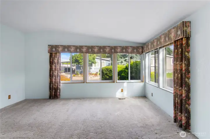 Formal living room is light and bright with all the windows.  The primary suite entry is to the far left.