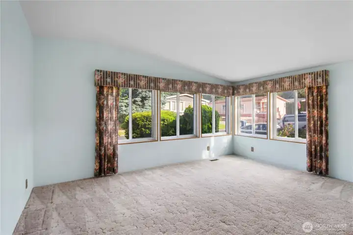The wall of windows overlooks the front walkway to the formal front entry.