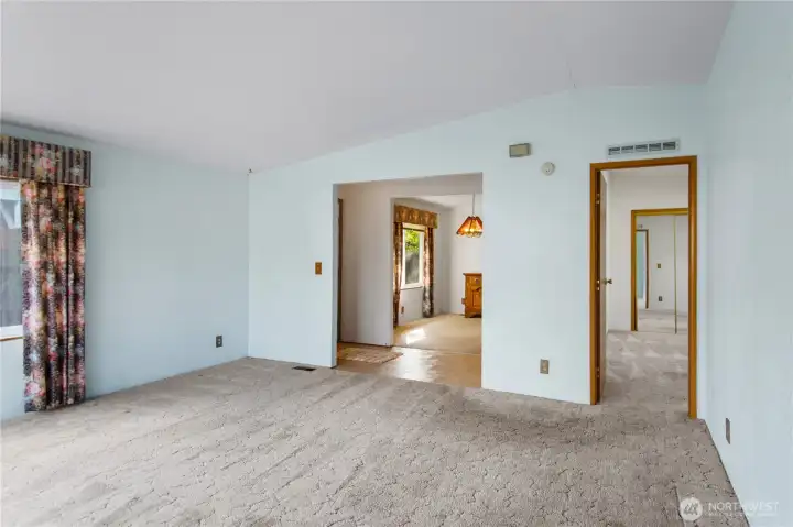 From the living room looking back to the front entry and dining room.  The entry to the primary suite is to the right.