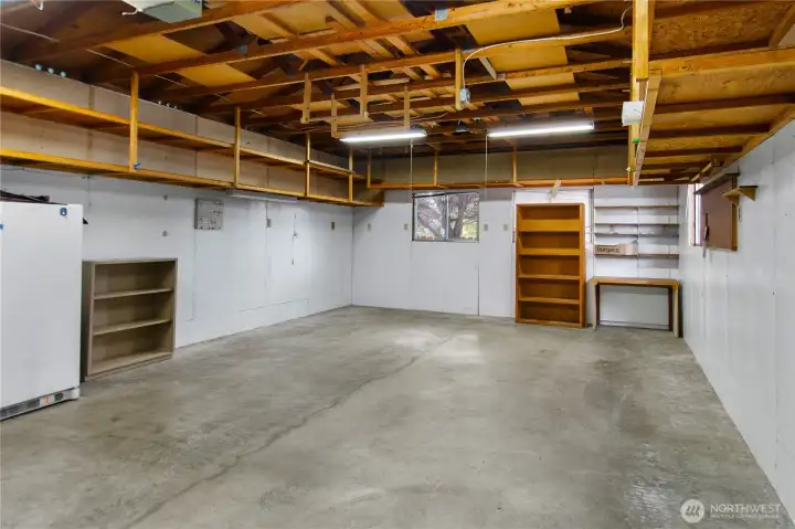 this double car garage has lots of storage shelves ready to go!  with the large driveway to park on, this space could be used for a workshop, or ?