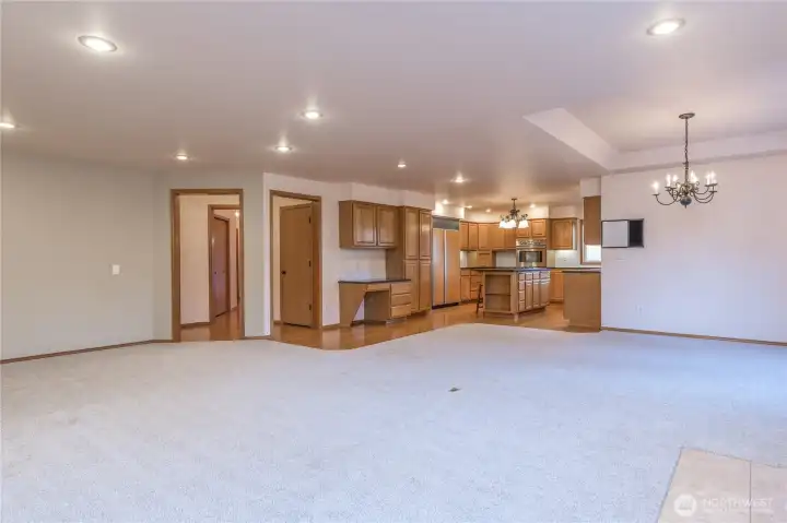 A view of the family room and kitchen, notice the flow from the rooms and extensive lighting