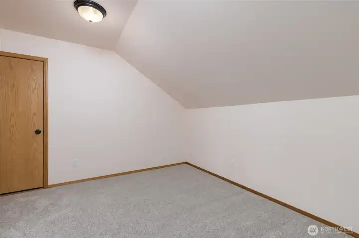 The upstairs bonus room, with an adjacent unfinished storage area.
