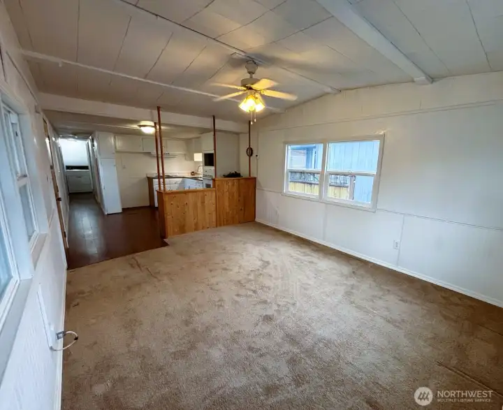 Big open living room with vaulted ceiling and windows on three sides