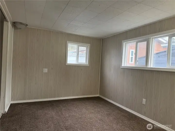 Primary bedroom with newly paneled walls and big windows