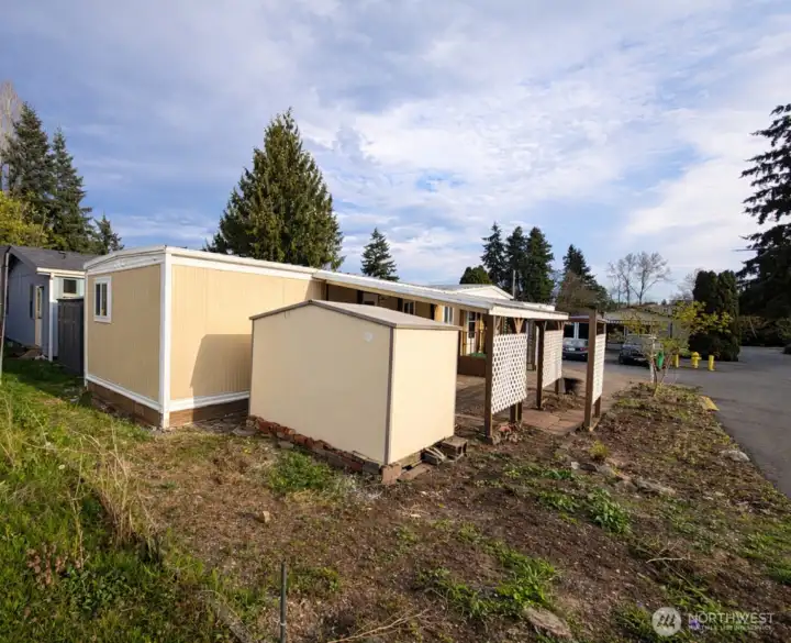 This is from the back corner of the home showing the fresh paint and large storage shed