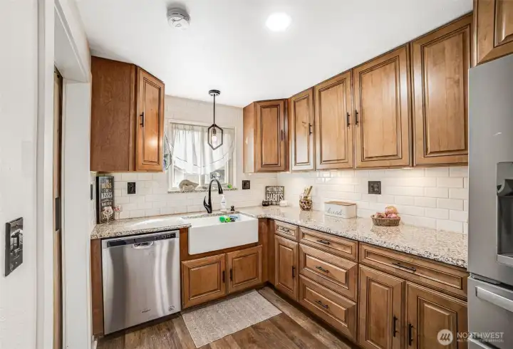 Gorgeous Cabinetry, farmhouse sink, stainless steel appliances, granite countertops, and this leads to your mud room and laundry area