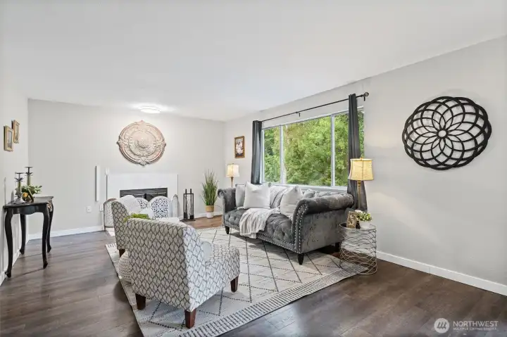 Spacious living area with wood burning fireplace (Seller is leaving the woodpile for your use).  The window looks out to the back yard.