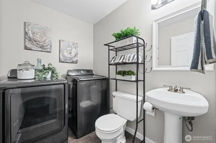 Main floor powder room and laundry. Washer and dryer stay with the home.