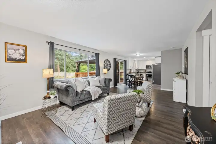 Full view of the living, dining, and kitchen open concept layout.  Add a peek into the backyard and patio gazebo.