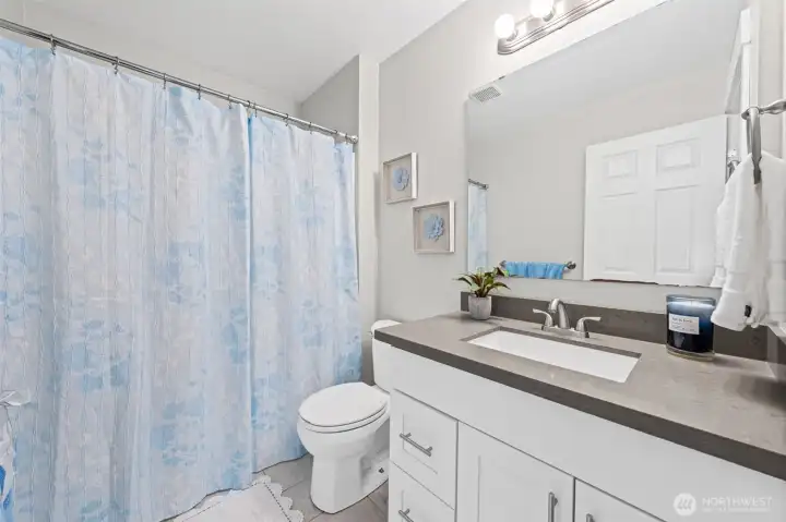 Hallway bathroom with undermount sink, and a tub/shower combo.