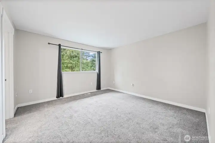 The private primary suite overlooks the peaceful backyard and features a full ensuite bath and oversized walk-in closet.
