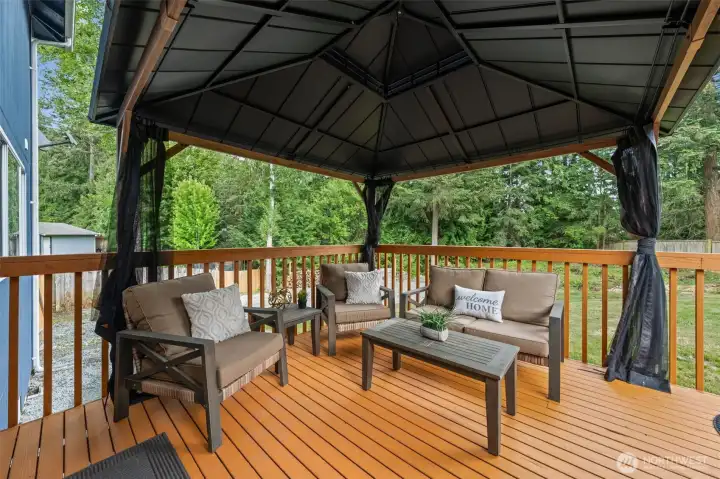 The attached back deck is complemented by a beautiful gazebo, creating the perfect space for al fresco dining, relaxing evenings, or enjoying your morning coffee year-round.