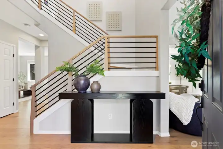 Two story entry way with new custom handrail and LVP flooring throughout entire main floor