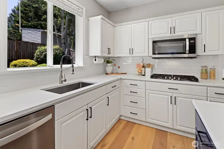 Updated kitchen with stainless steel appliances including gas range, shaker cabinets, walk-in pantry