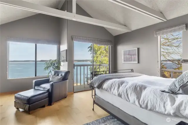 Primary bedroom offers vaulted ceilings, walkout balcony, and views from every window.