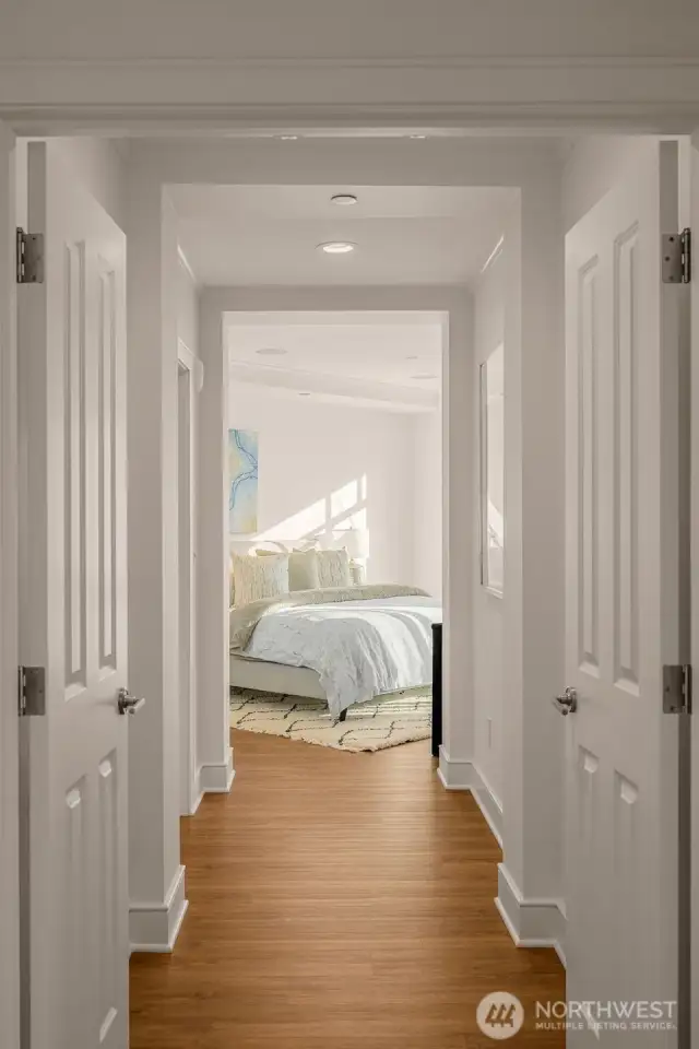 Proceed down the hallway through double french doors to the primary bedroom