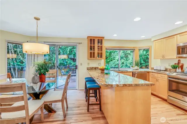 The open-concept kitchen flows into the dining area, where sliding glass doors lead to the expansive deck. Enjoy effortless entertaining with easy access to the beautifully landscaped backyard.