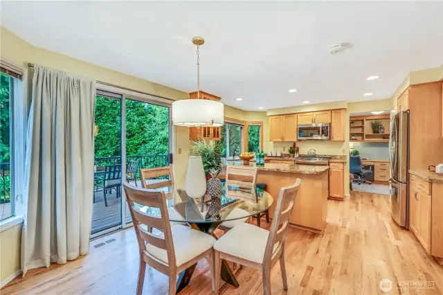 This open-concept kitchen and dining area offers abundant natural light, thanks to large windows and sliding glass doors that lead to the deck. The refinished hardwood floors add warmth, while the spacious layout allows for easy meal preparation and entertaining. Granite countertops provide durability and elegance, making this kitchen both stylish and functional.