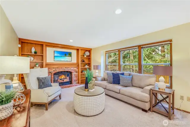 This angle showcases the large picture windows which allow for natural light to flood the space while providing a stunning view of the surrounding landscaped backyard.