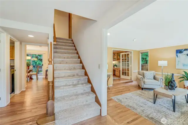 Step inside to discover refinished hardwood floors and new carpeting that enhance the home’s warmth and elegance. The open staircase creates a stunning focal point, while natural light fills the entryway.