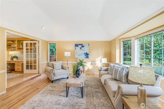 A vaulted ceiling and oversized bay window flood this room with natural light. Crisp white trim and refinished hardwood floors provide a neutral canvas, ready for your personal touch.