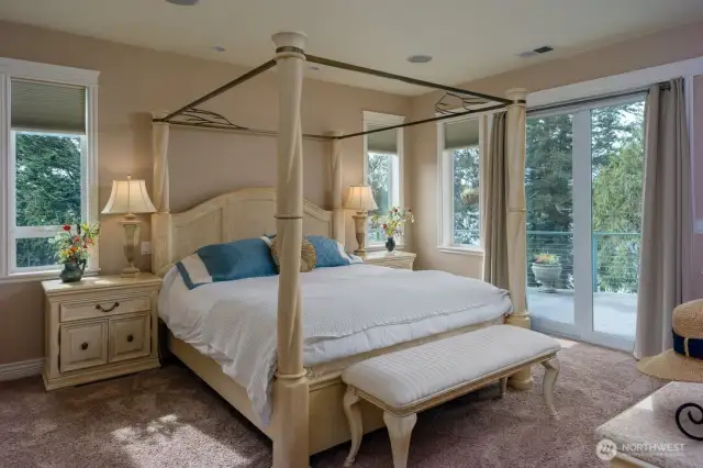 Generously sized, main level, primary bedroom with water views and doors leading to expansive deck.