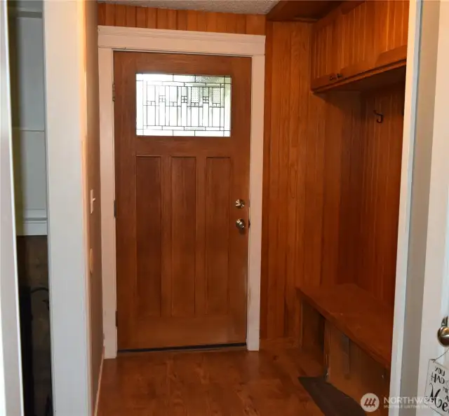 Beautiful entry door with convenient coat and shoe area and a place to sit.