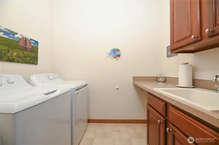 Laundry room with utility sink,cabinet and folding table.