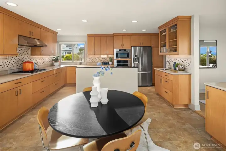 This shot nicely demonstrates the circular flow.  Immediately to our right is the dining room.  The doorway to the right of the fridge is where we were just standing, leads to entry and upper lower stairs, then circles around through living and dining rooms.