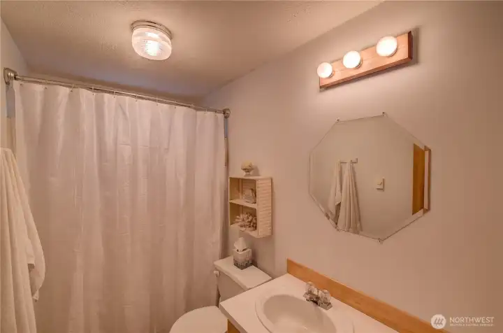 Guest bathroom is complete with shower/tub combo.