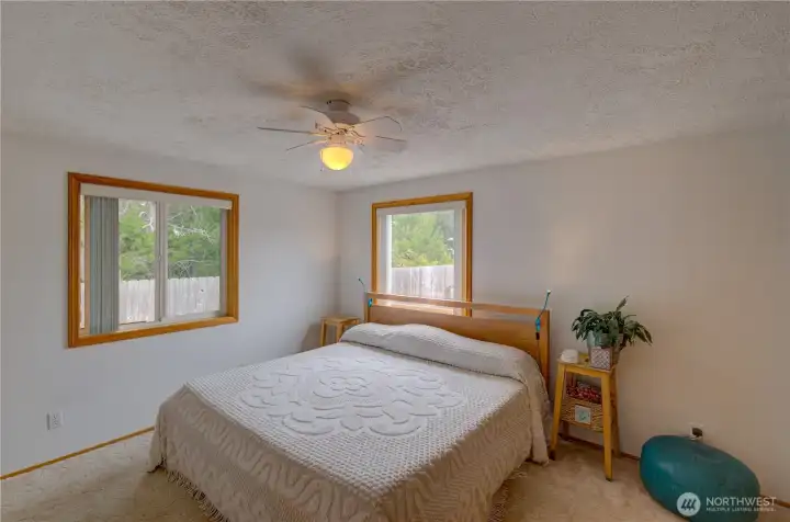 Primary Bedroom with windows that look out into the back yard.