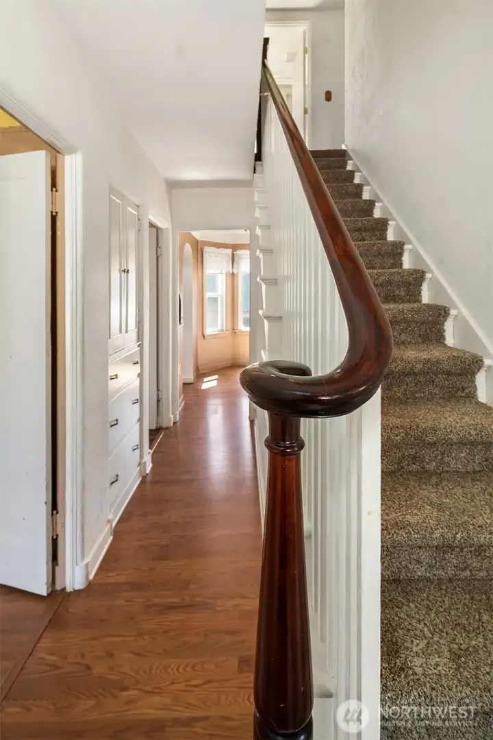 Lovely stairwell heads up to full bath and 2 bedrooms