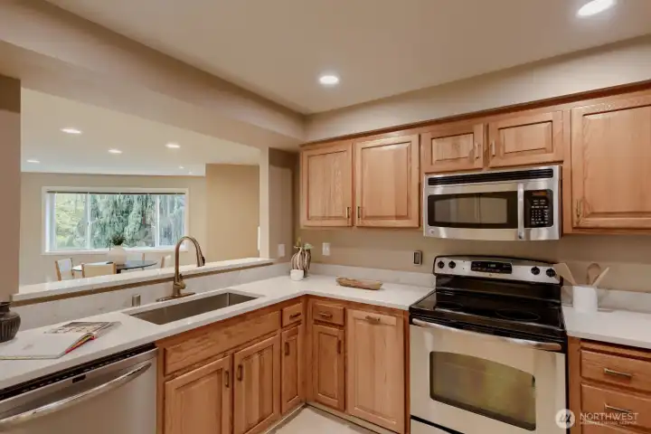 Updated Kitchen - Complete with Window Views, Service Bar to Open Living & Dining, Quartz Counters & Stainless Steel Appliances