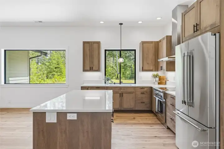 Designer kitchen featuring quartz countertops, stainless appliances, and large island. Designer kitchen featuring quartz countertops, stainless appliances, and large island.