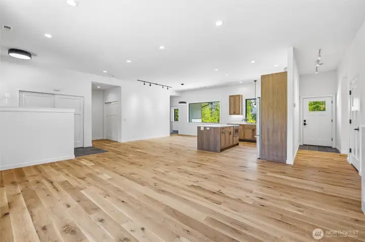 Spacious open-concept living area with warm wood flooring and abundant natural light. Spacious open-concept living area with warm wood flooring and abundant natural light.
