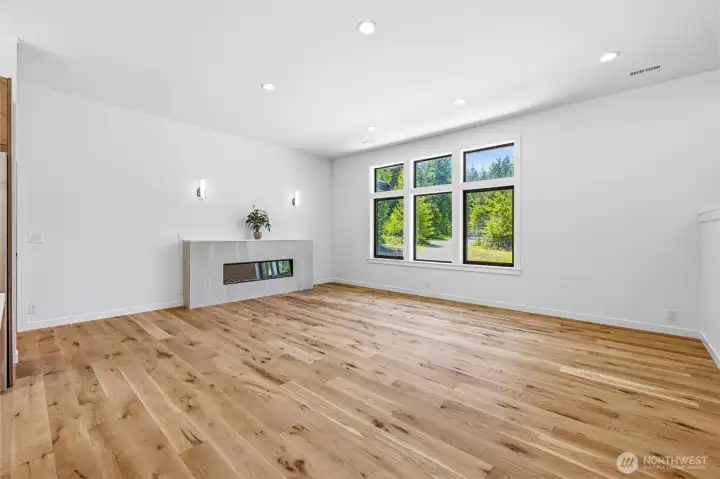 Expansive living room featuring modern fireplace and oversized windows. Expansive living room featuring modern fireplace and oversized windows.