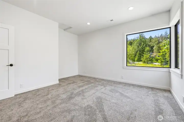 Comfortable bedroom featuring oversized picture window and serene views. Comfortable bedroom featuring oversized picture window and serene views.