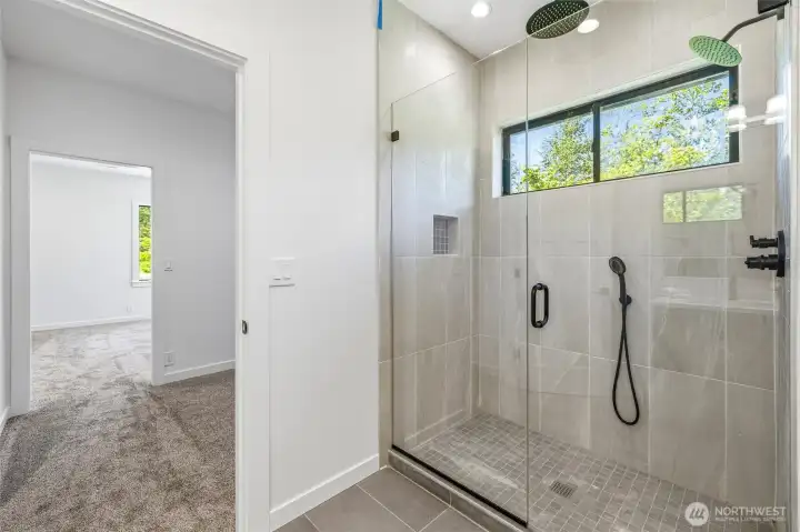 Luxurious walk-in shower with designer tile and modern fixtures. Luxurious walk-in shower with designer tile and modern fixtures.