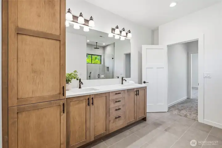 Spacious bathroom featuring dual sinks and custom cabinetry Spacious bathroom featuring dual sinks and custom cabinetry