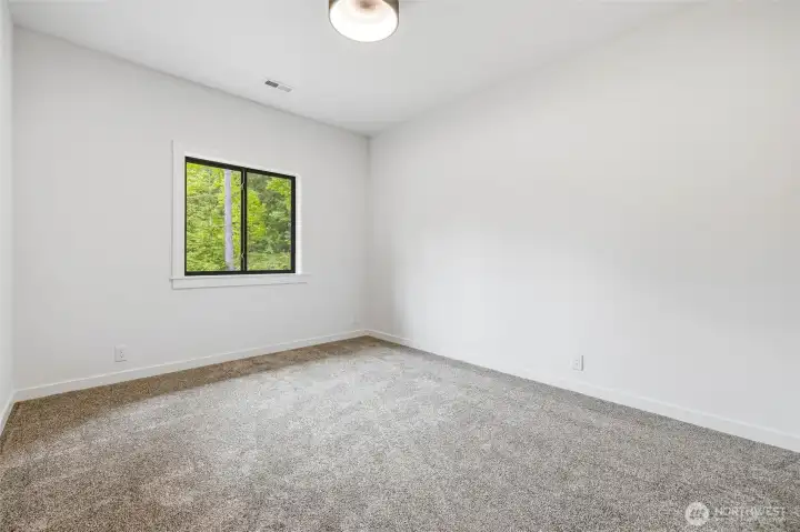 Bright secondary bedroom with large window and peaceful views. Bright secondary bedroom with large window and peaceful views.