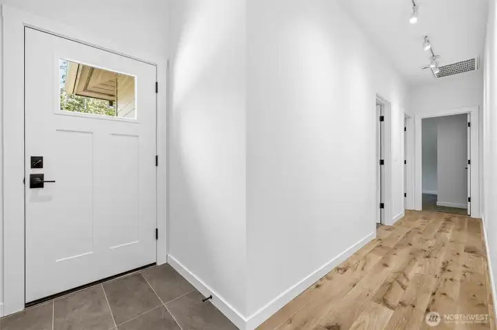 Wide hallway with clean modern finishes and recessed lighting. Wide hallway with clean modern finishes and recessed lighting.