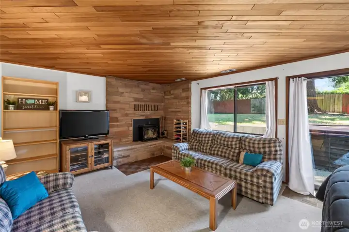 Lower floor large family room with cozy wood-burning fireplace & beautiful wood ceiling opens to the large patio.