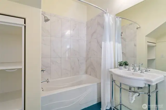 Main Floor Full Bathroom with pull outs to access additional storage.