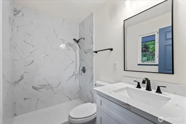 En-suite bathroom with tile surround, walk-in, zero-curb shower.