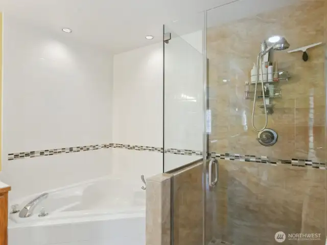Modern soaking tub and shining shower with beautifully designed tile/granite crftsman detail.