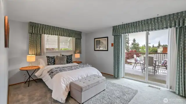 This primary bedroom floods with natural light and offers direct access through a sliding door to a spacious outdoor patio perfect for setting up a cozy table and chairs to unwind and relax