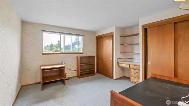 Upstairs, a versatile bonus room awaits—perfect as a guest room, office, or whatever you need—with two closets and built-in desk shelves providing plenty of extra storage to help you stay clutter-free