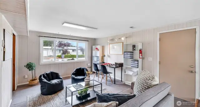 Discover a roomy extra living area where you can arrange your favorite furnishings or simply relax, complete with display shelves, ample space for personal touches, and bright natural light from outside